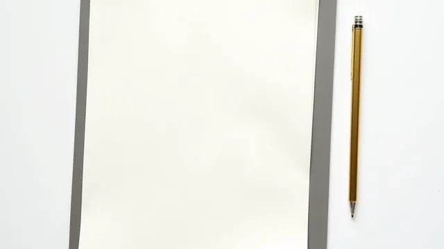 Hojas en blanco y un lápiz dorado sobre una mesa